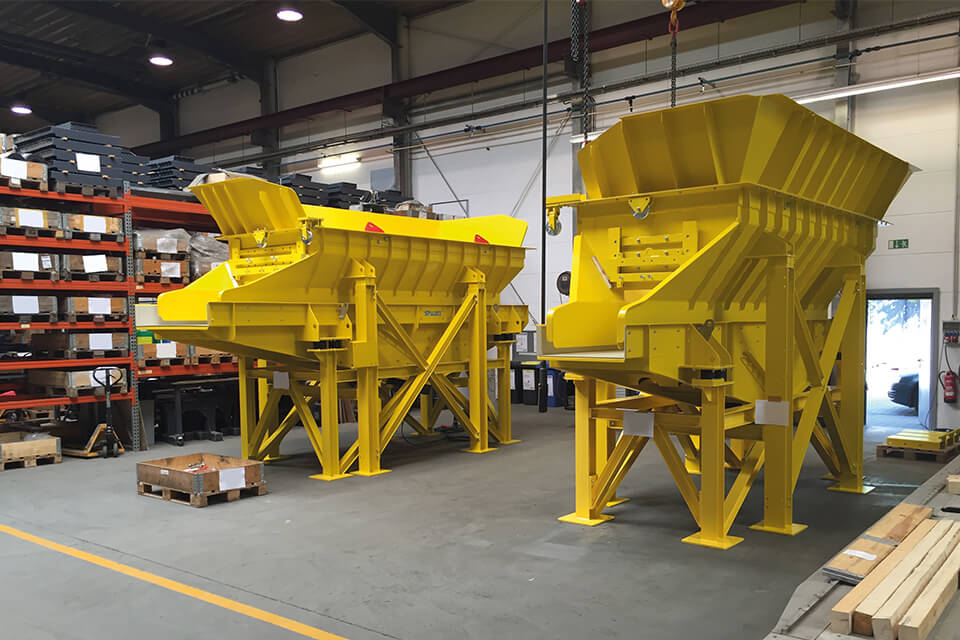 Two yellow feed hopper for shredder heavy fraction in metal recycling