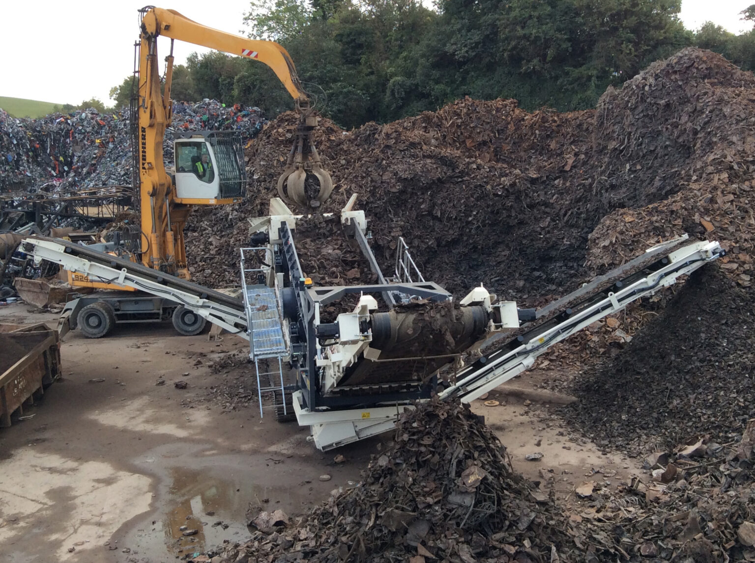 Mobile screening plants used to process scrap material at a recycling facility.