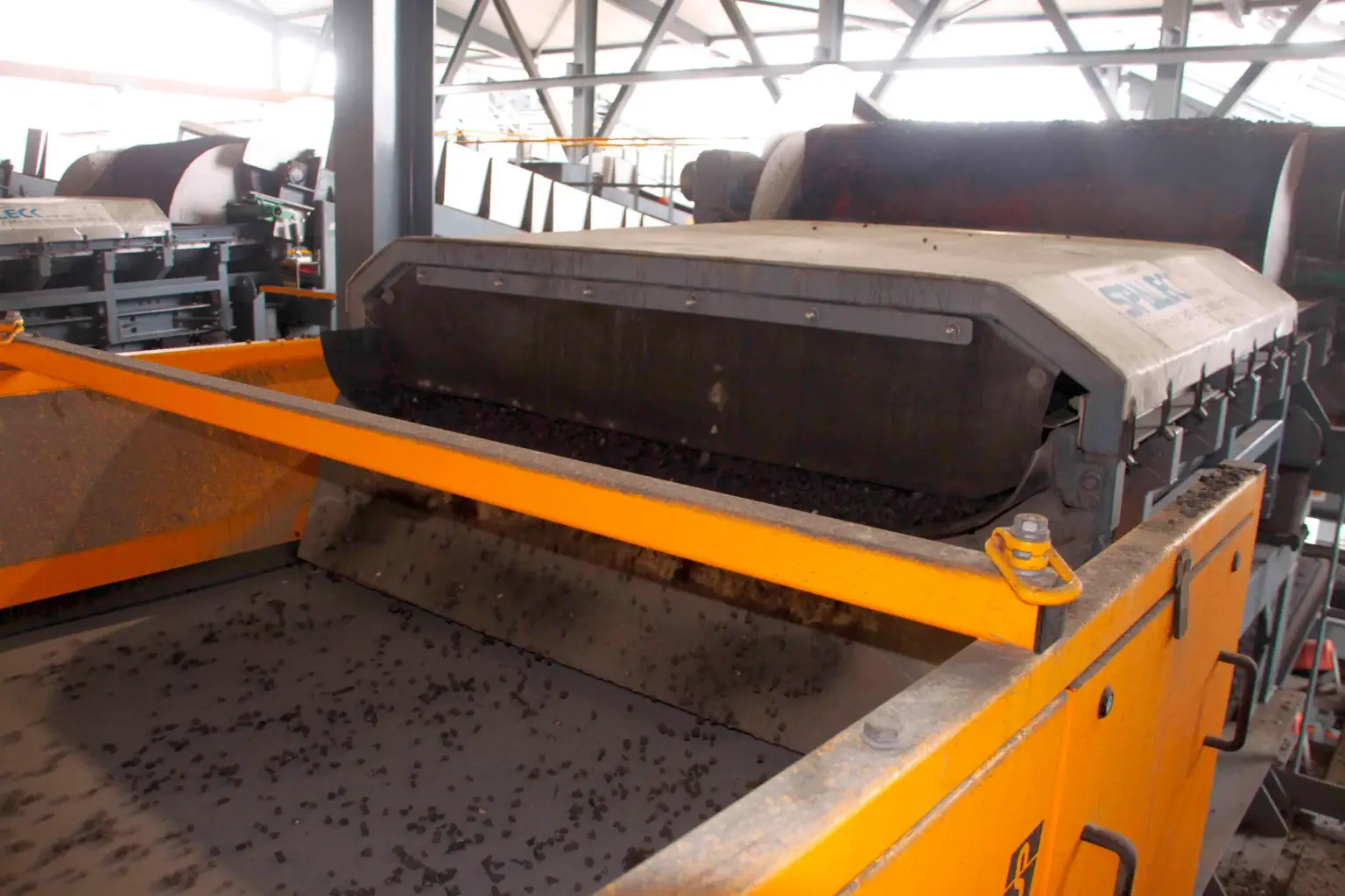 SPALECK ActiveCLEAN self-cleaning vibrating conveyor trough in a slag processing plant, conveying MV slag to an eddy current separator (NES)