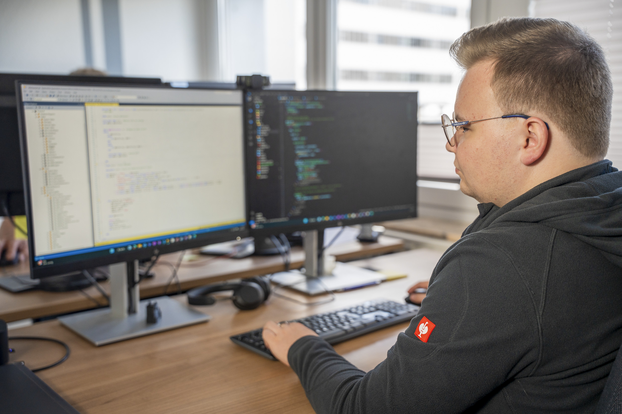 An apprentice system integration specialist programs on a computer
