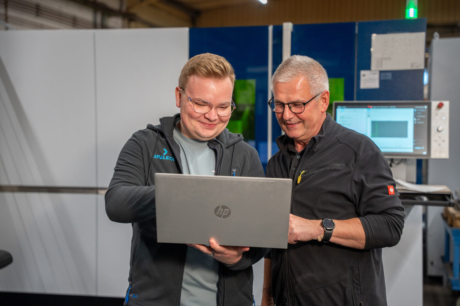 An apprentice application developer works with colleagues on a laptop