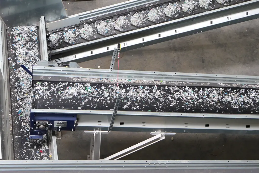 Conveyor belts carrying plastic waste that has been screened by SPALECK screening machines according to size, which is then sent for further sorting using NIR sorting machines.
