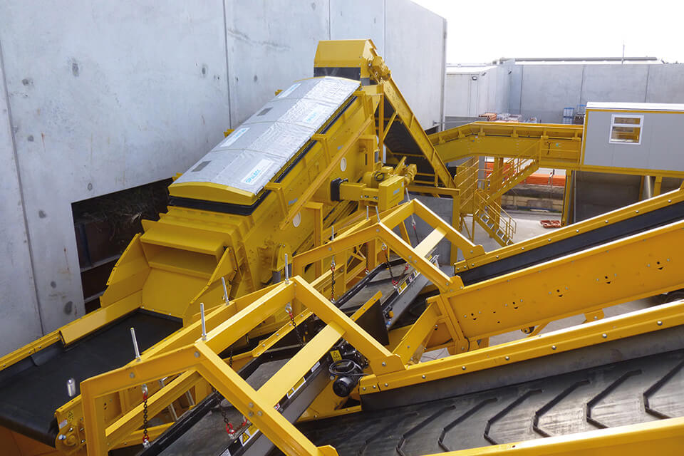 Yellow recycling plant for mixed construction waste with conveyor belts.