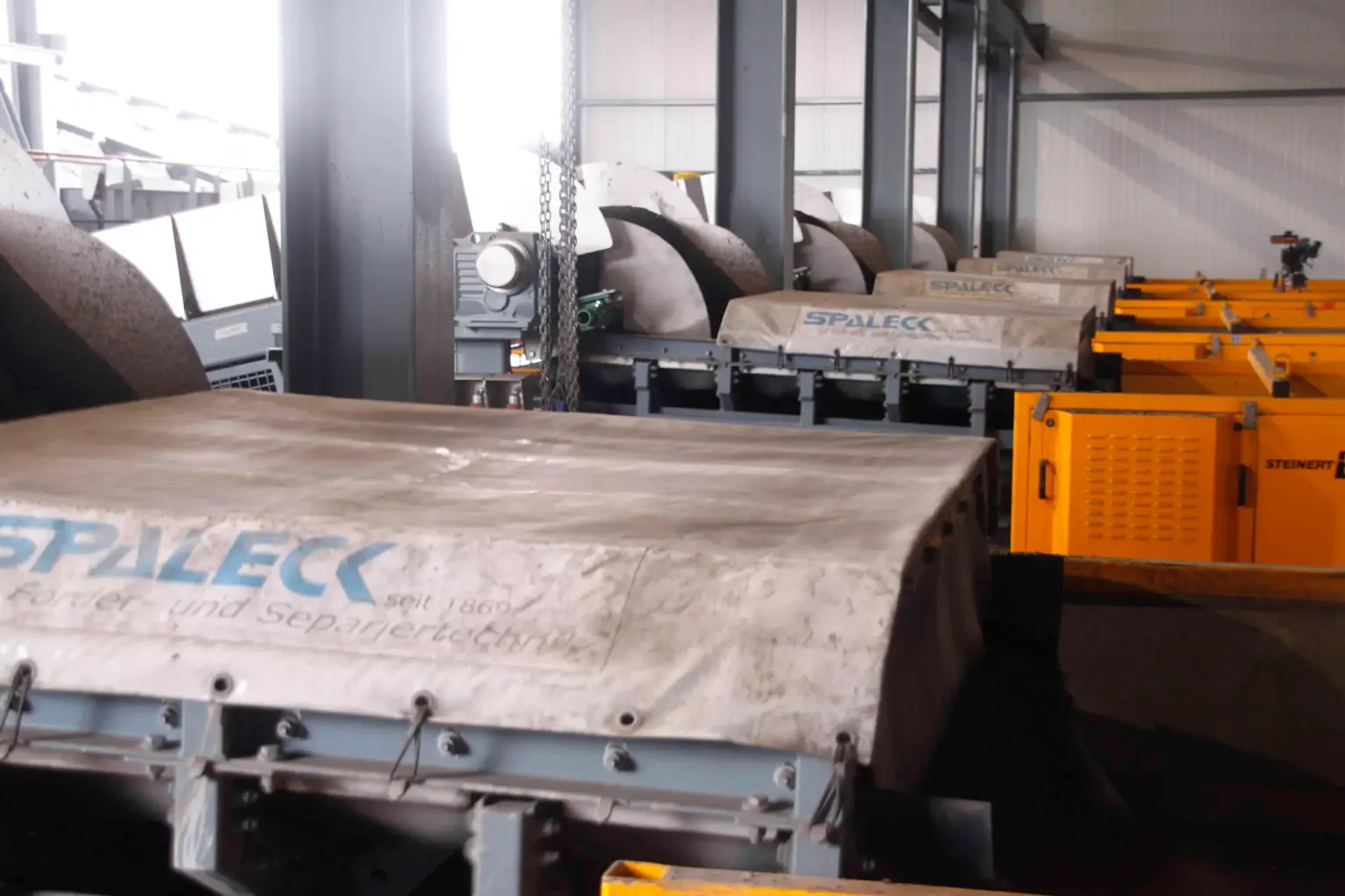 SPALECK ActiveCLEAN vibrating conveyor chutes in use in slag processing; here, they ensure a clog-free feed to the sorting equipment
