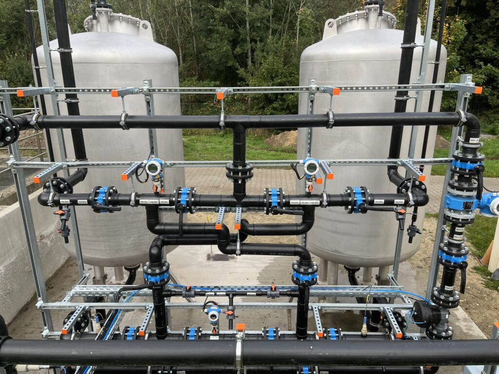 A water treatment system for raw water and well water, with pipes and tanks located outdoors.
