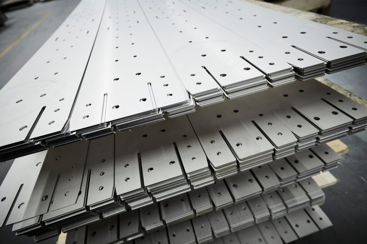 Laser-cut parts stacked at SPALECK, a metal fabrication contractor