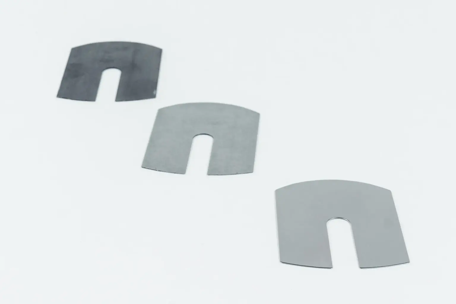 Three metal components with U-shaped cutouts on a white background.