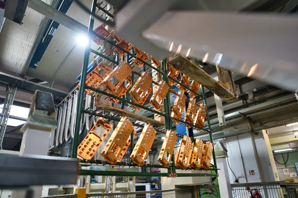 Electroplating of components as a processing step in surface finishing—here, components before immersion in the electroplating tank