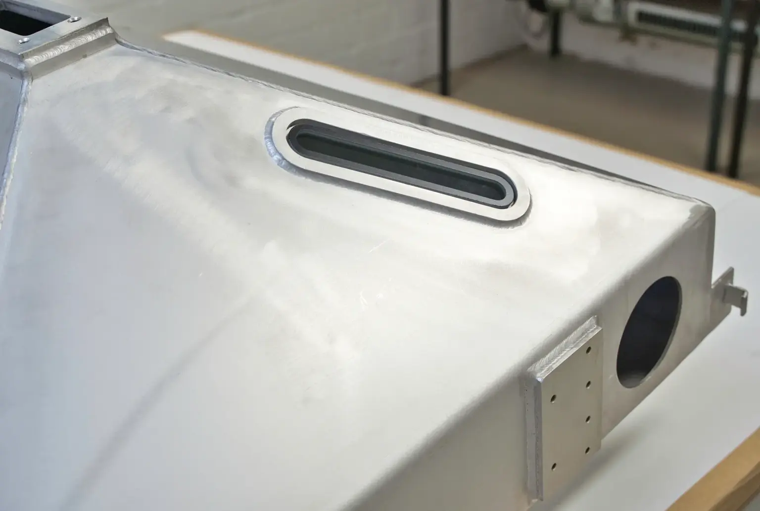 Welded assembly with an adhesive-bonded sight window in accordance with EN 17460