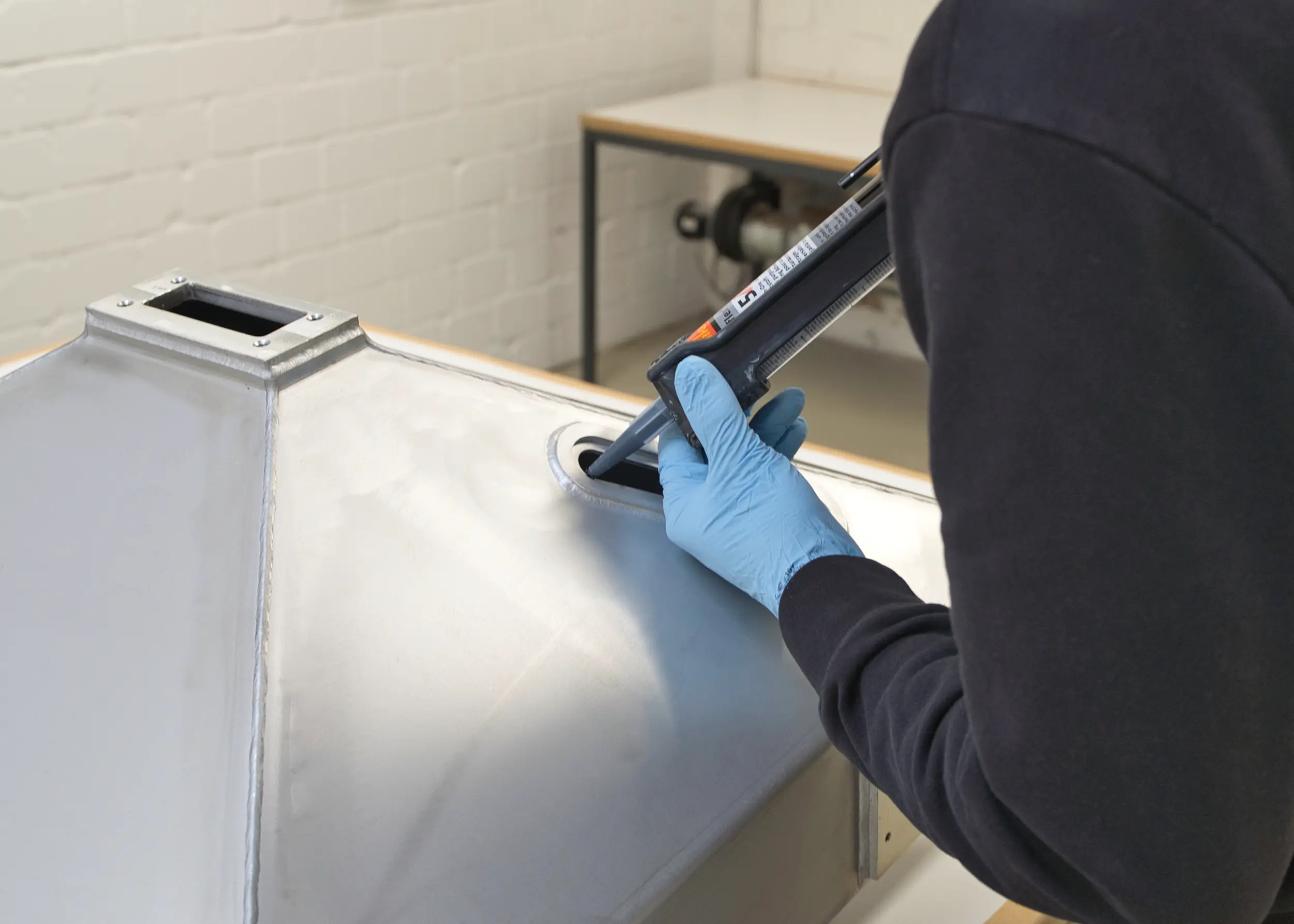 A SPALECK employee is bonding a rail vehicle component in accordance with EN 17460