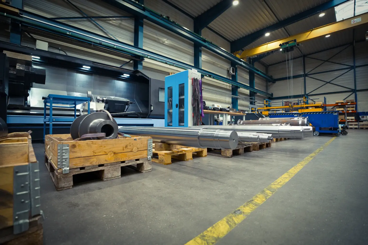 Industrial warehouse with long turned parts on pallets.