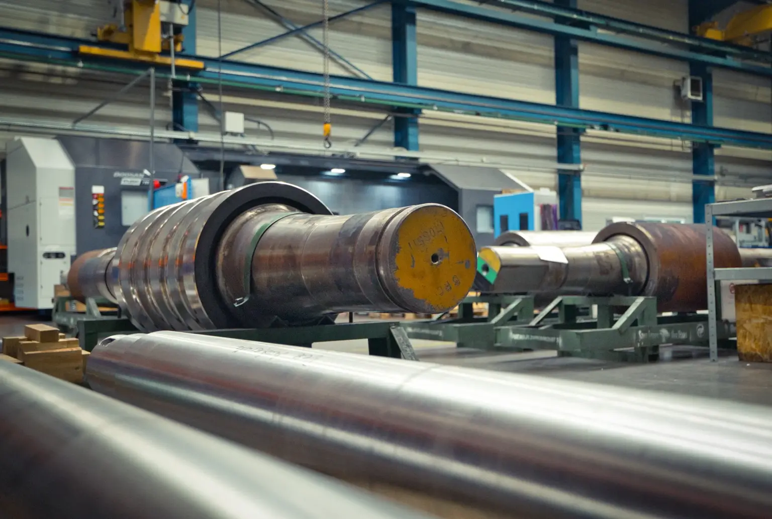 Large metal cylinders in a factory building, suitable for long turned parts.