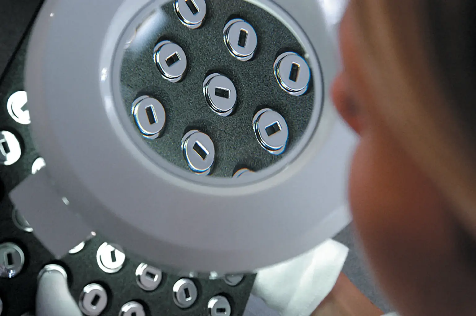 Quality Assurance for Galvanized Small Parts — QA Employee Looks Through a Magnifying Glass