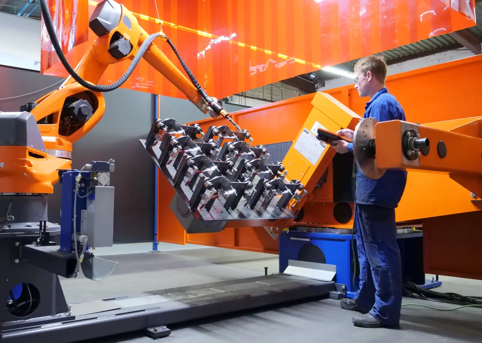 A mechanical fitter instructs and trains a welding robot on how to weld a component at the contract manufacturer SPALECK