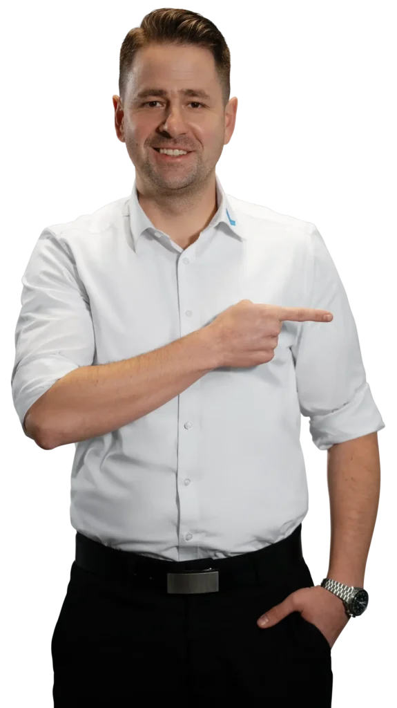 A man in a white shirt is pointing to the right; the focus is on metalworking.
