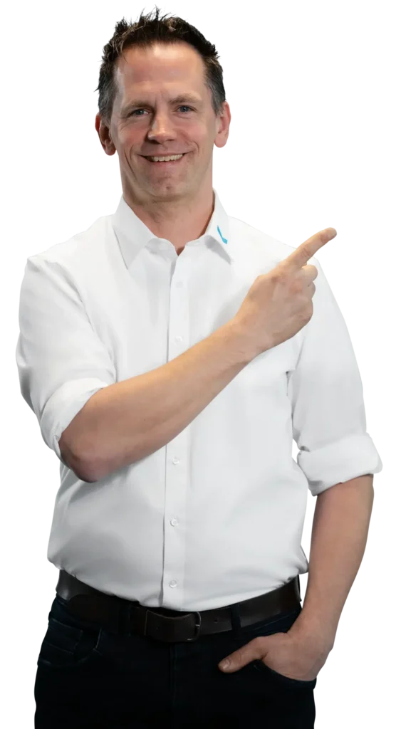 A man in a white shirt is smiling and pointing to the side.