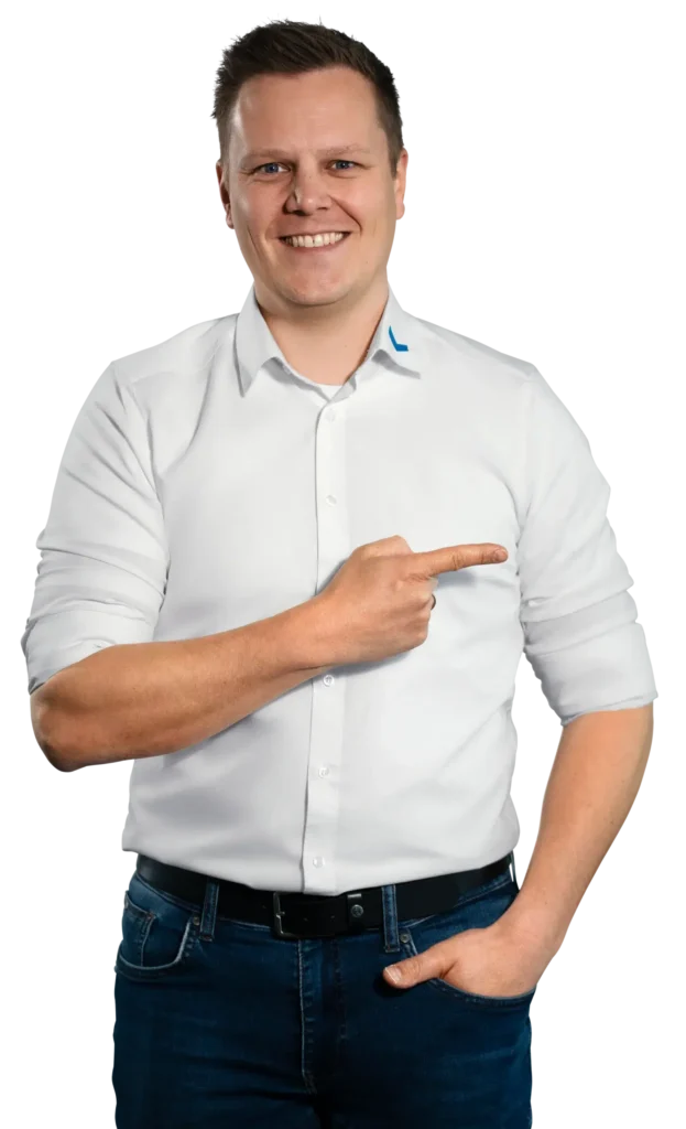 A man in a white shirt is smiling and pointing to the side.