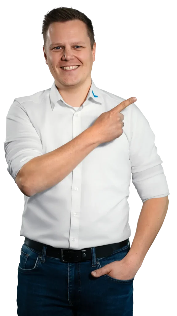 A man in a white shirt is smiling and pointing to the right.