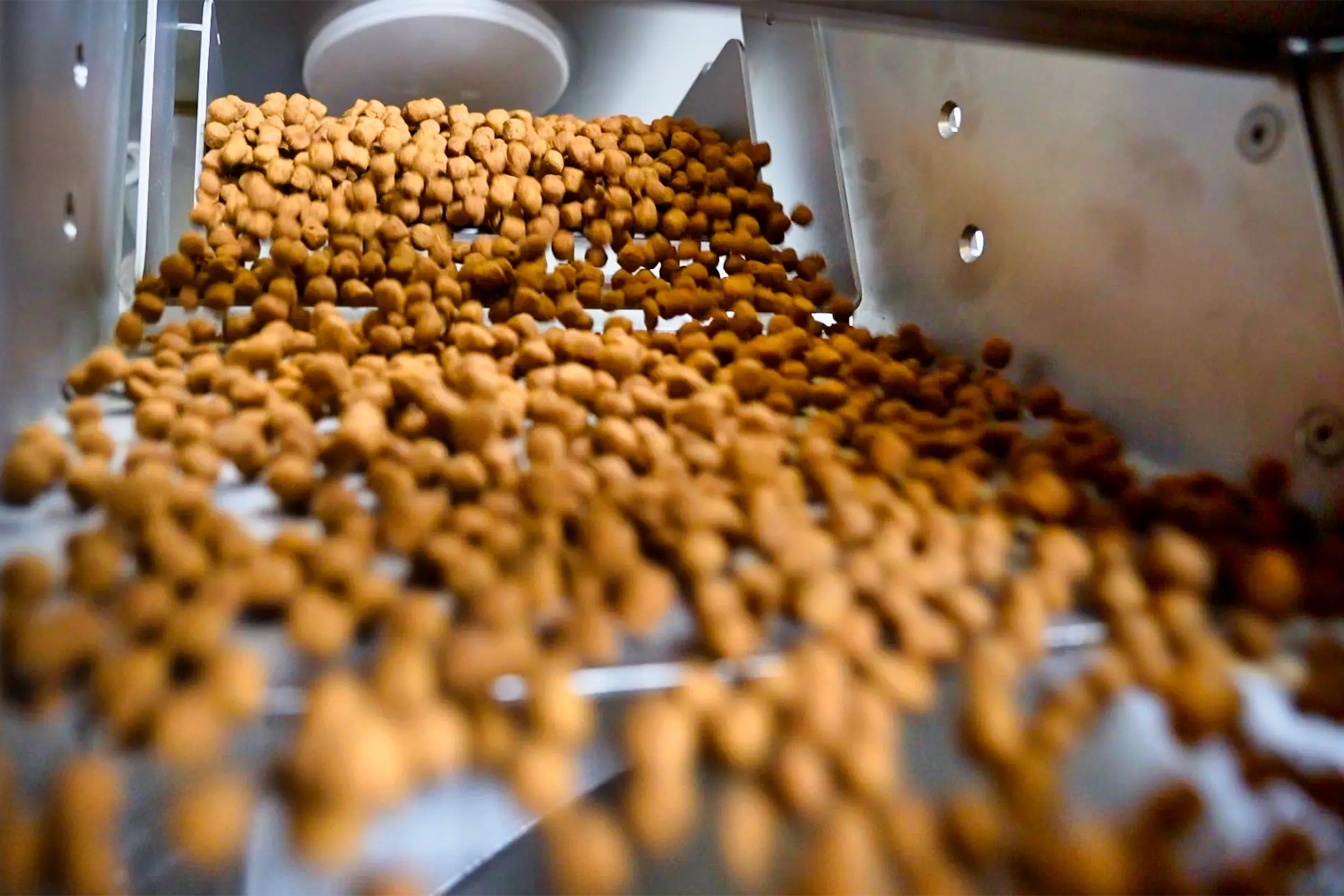 Animal feed screeners sift brown pellets.