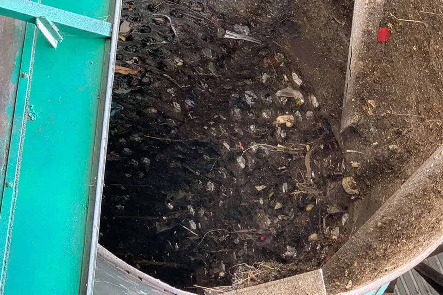 A drum screen filled with soil and organic material.